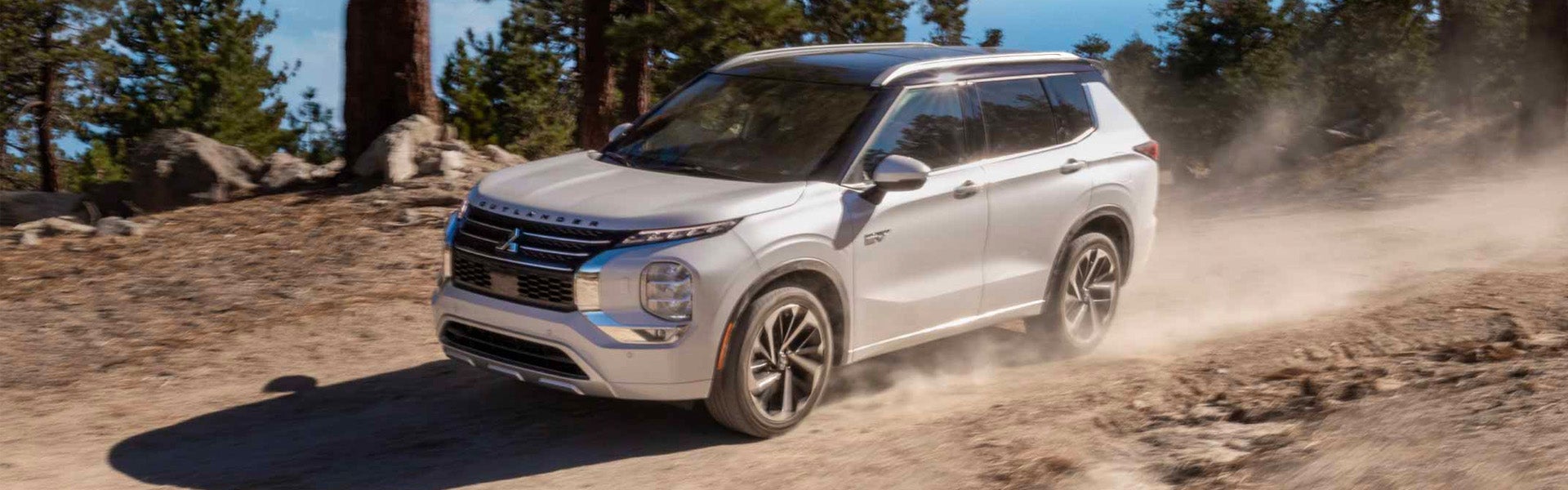 White 2025 Mitsubishi Outlander Hybrid on dirt forest road