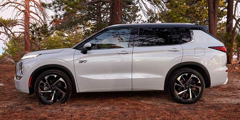 White 2025 Mitsubishi Outlander Hybrid in forest